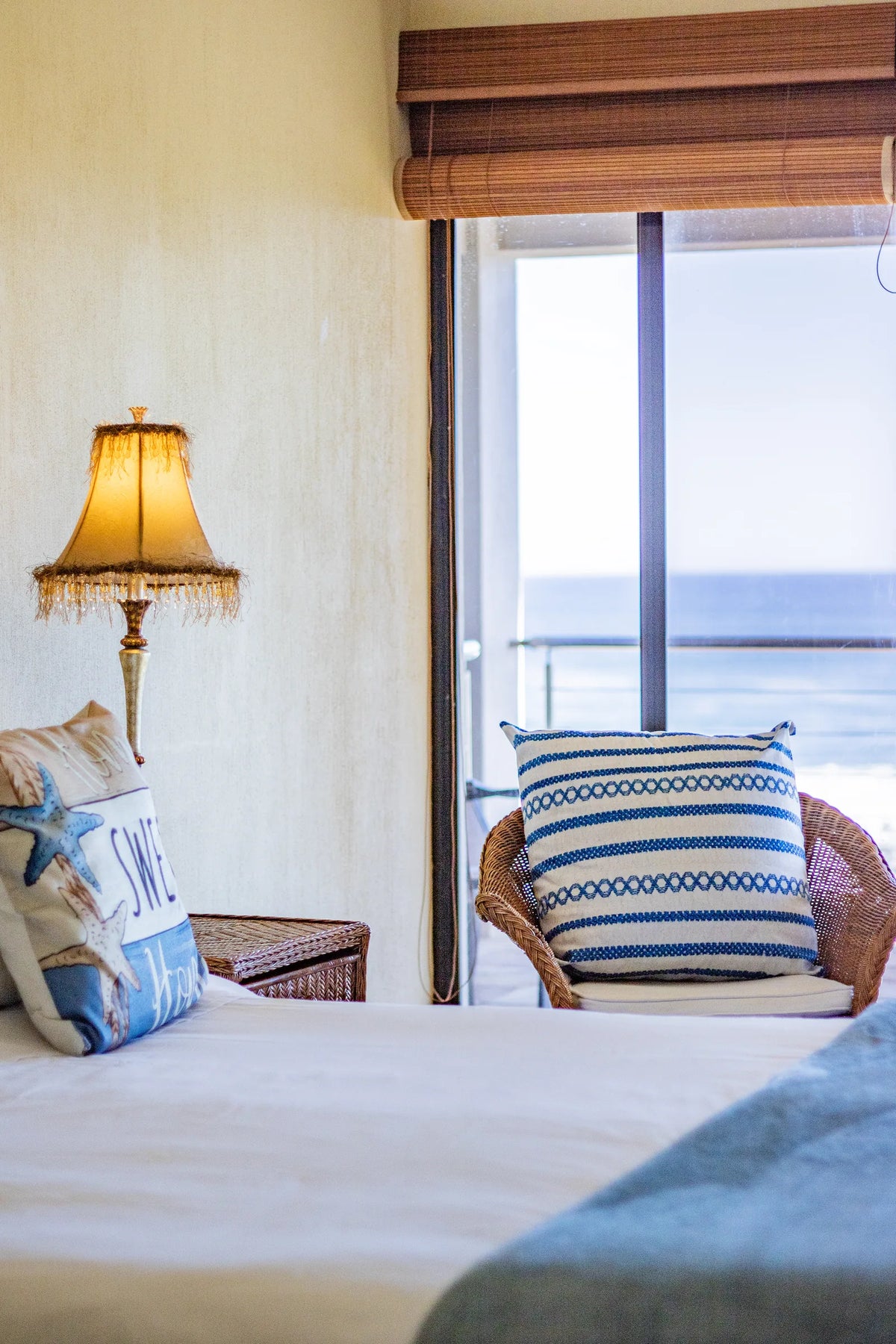 A bedside with the ocean through the window