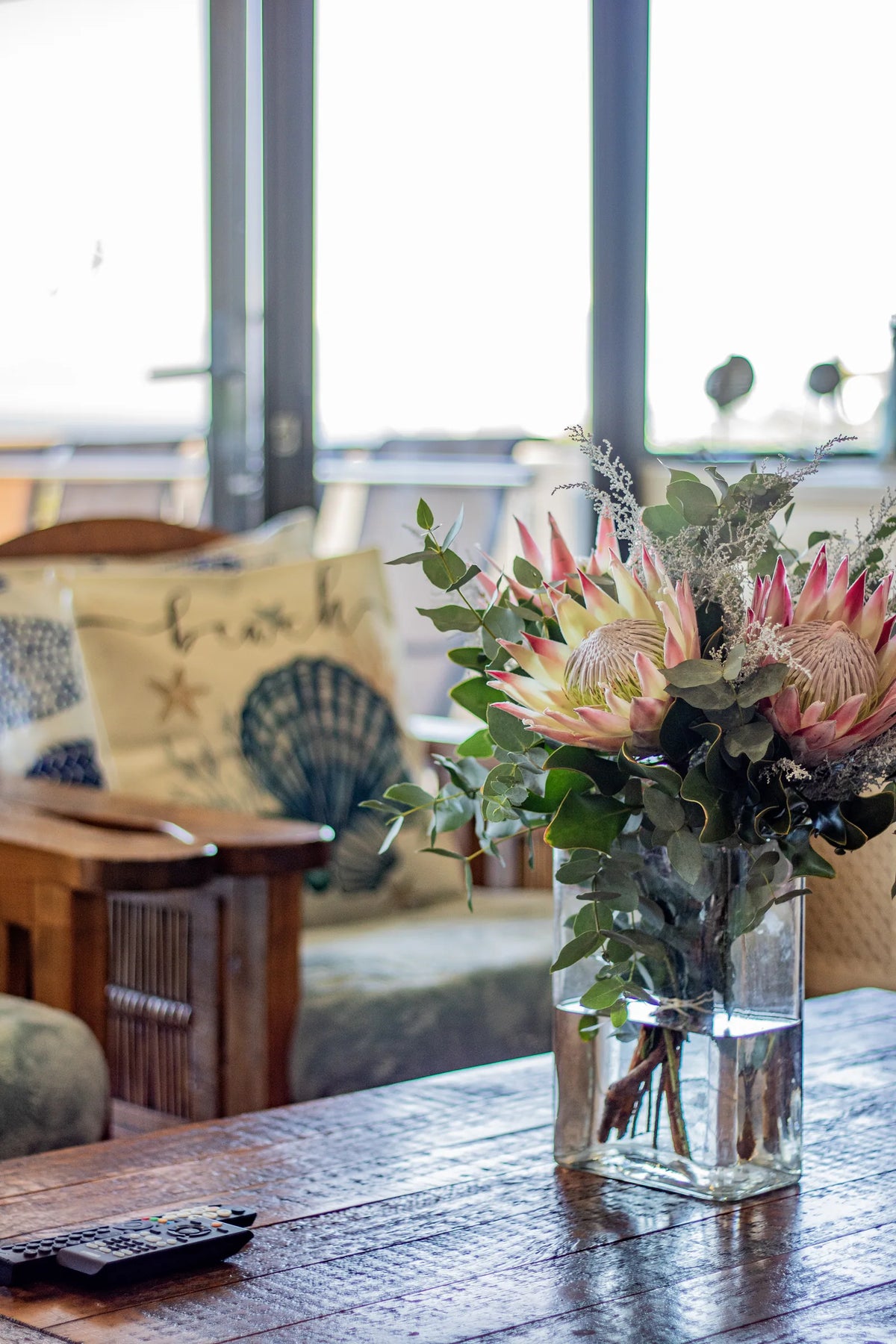 A sitting corner with fresh proteas by the window