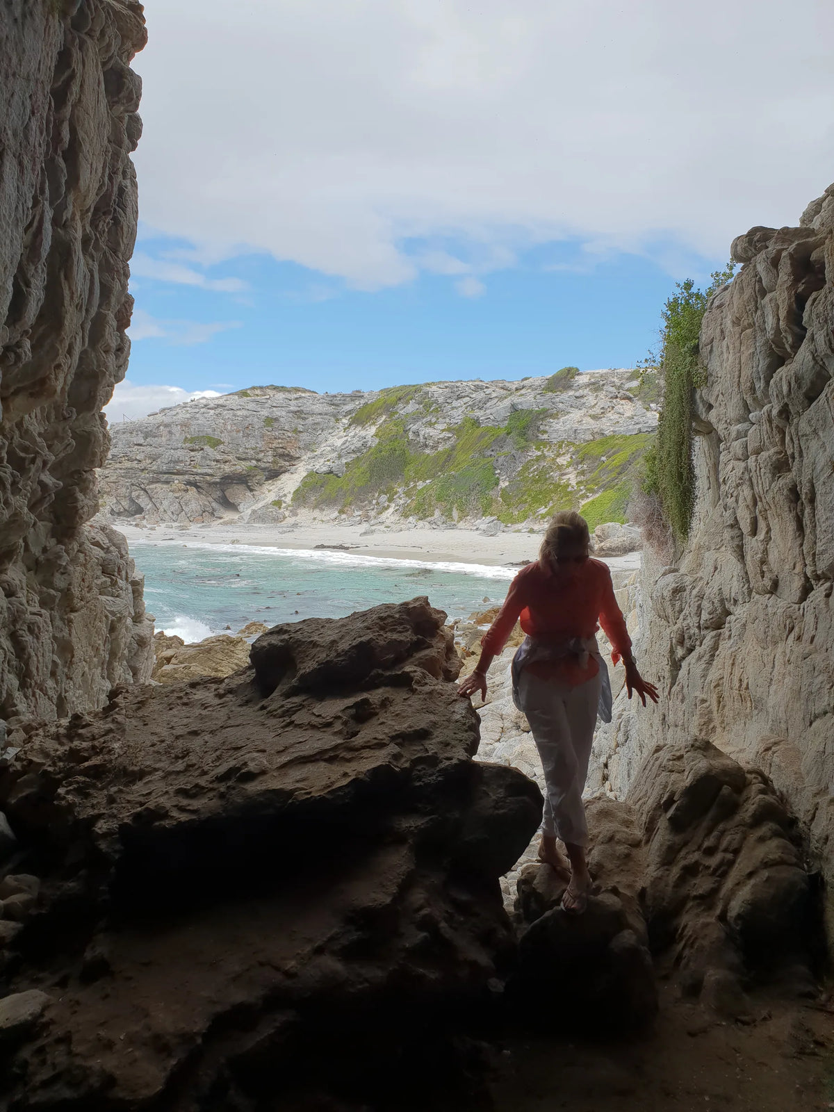 Walking out of a sea cave onto the De Kelders shoreline