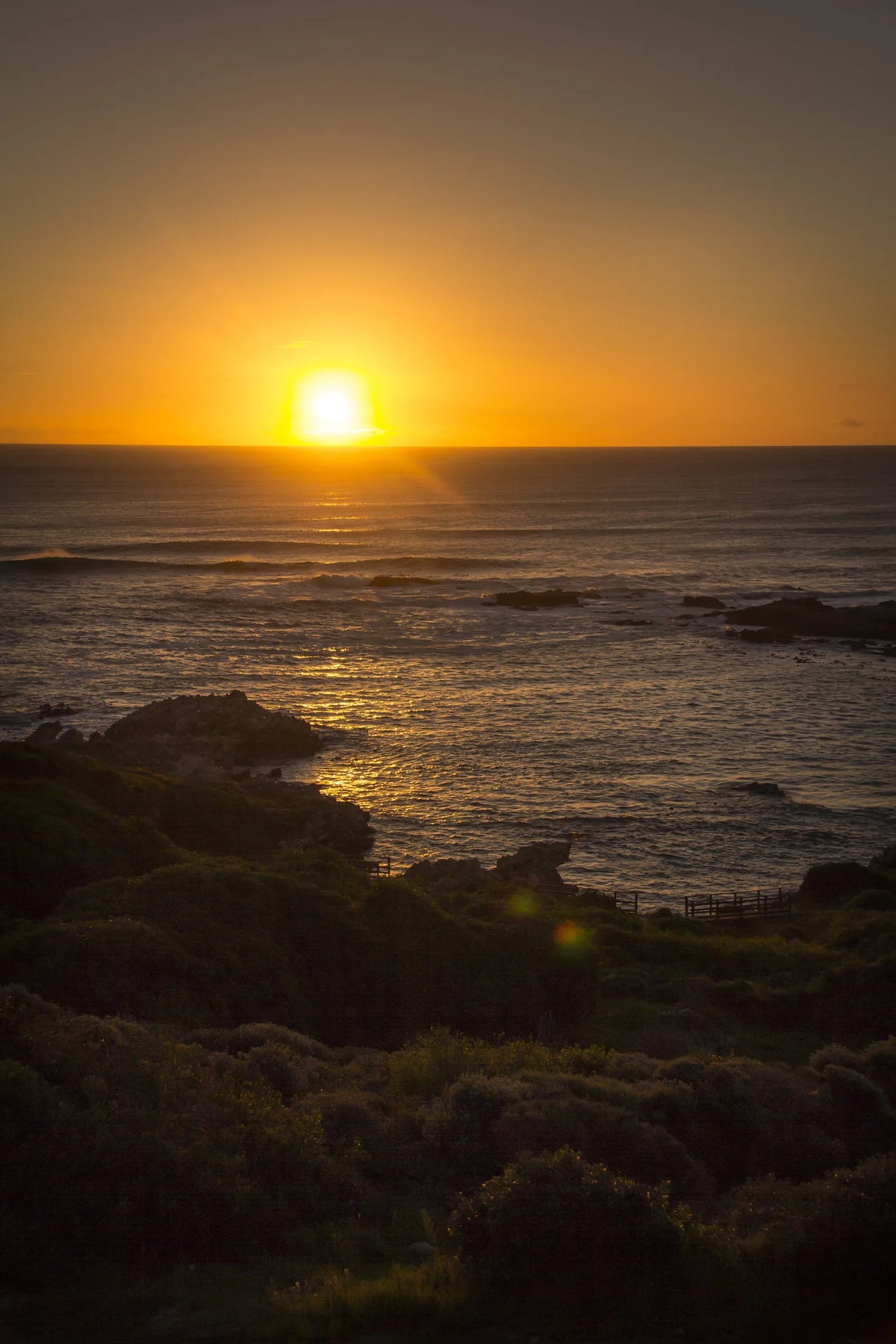 The sun setting into the sea off De Kelders