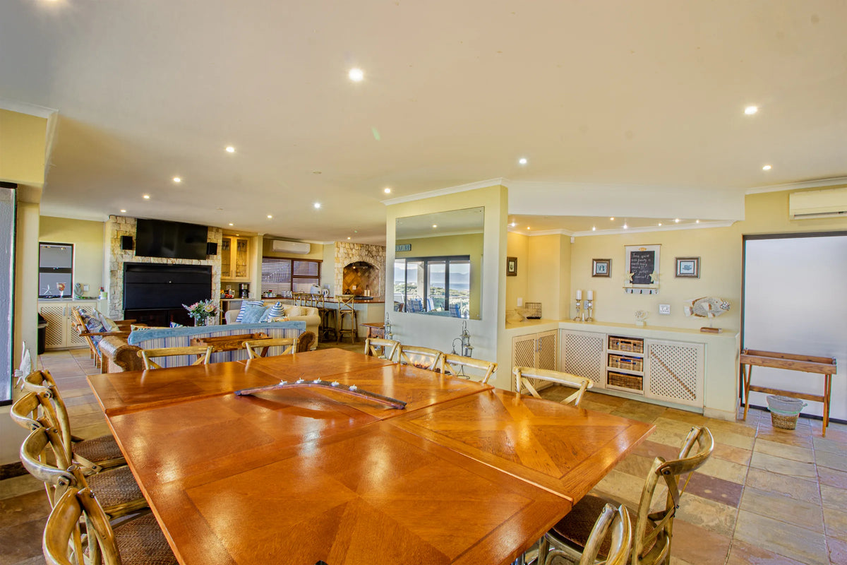The dining table set for a group, with the lounge beyond