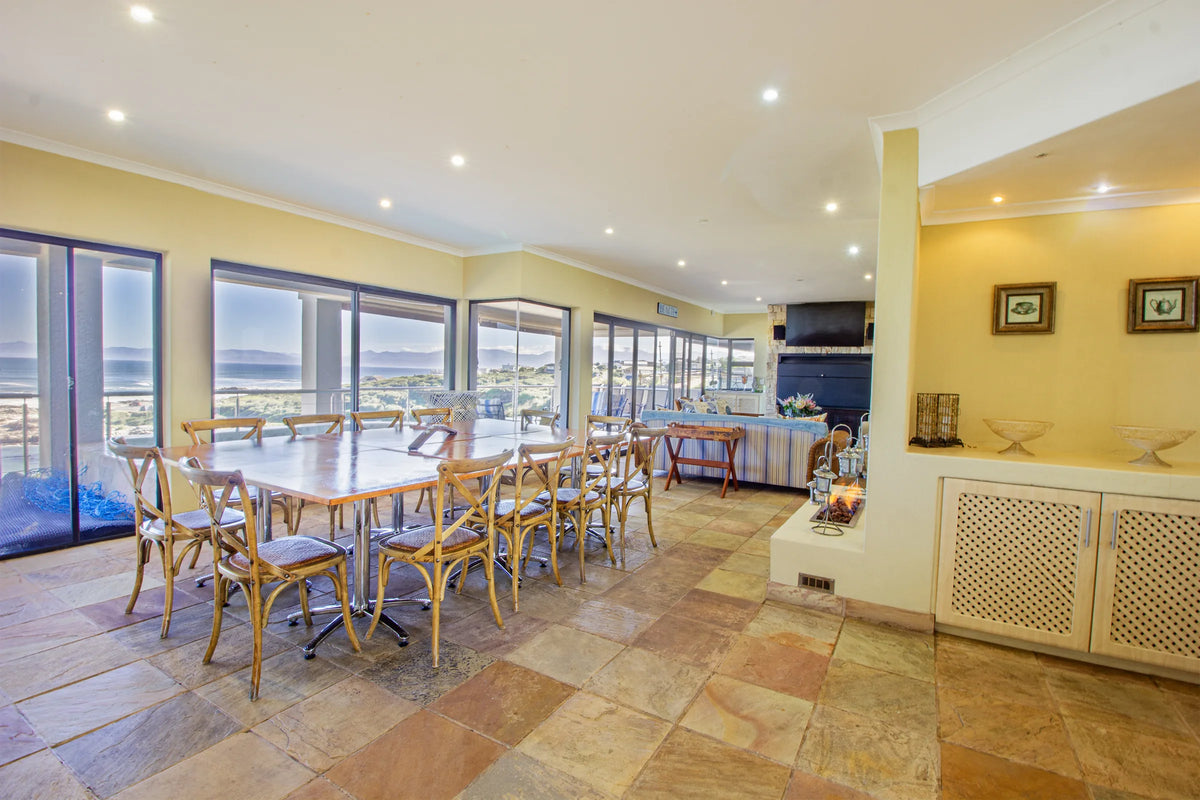The dining table beneath windows onto Walker Bay