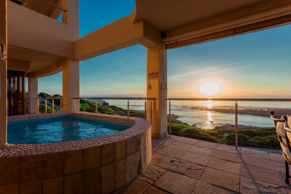 The plunge pool on the stoep at sunset, with Walker Bay beyond